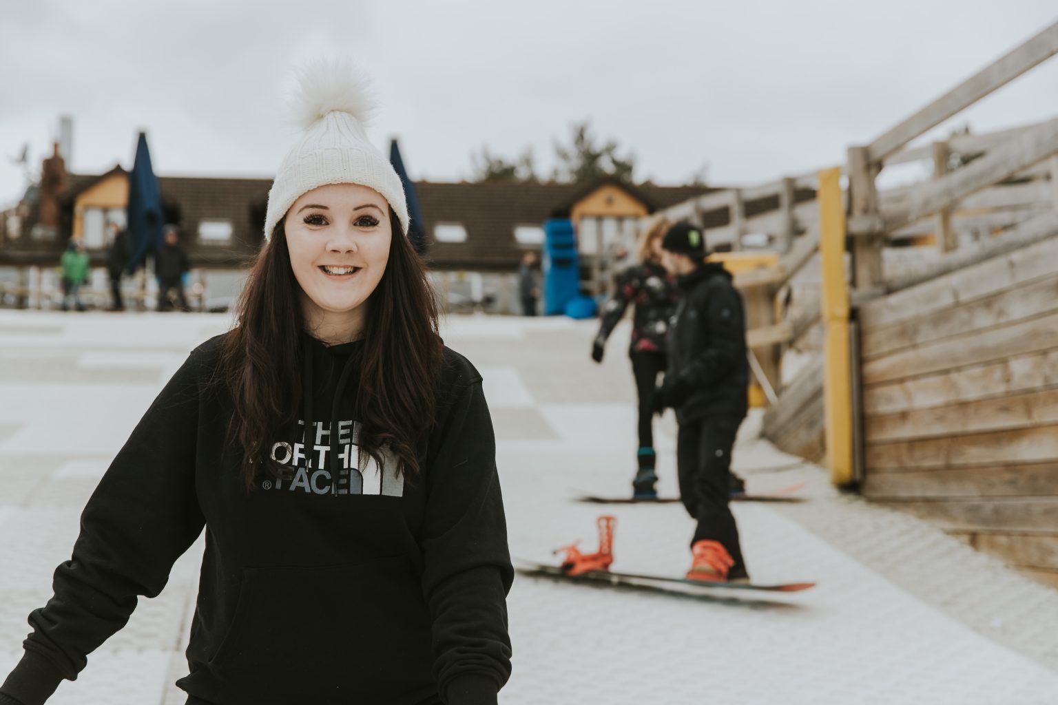 A snowboarder riding down an open daytime slope