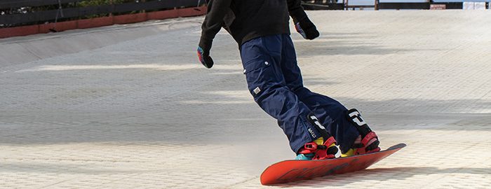 A snowboarder riding through fresh snow at speed